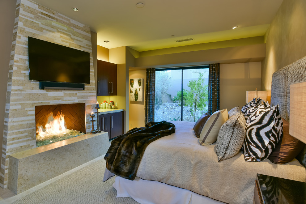 Large trendy guest travertine floor bedroom photo in Other with beige walls, a standard fireplace and a tile fireplace