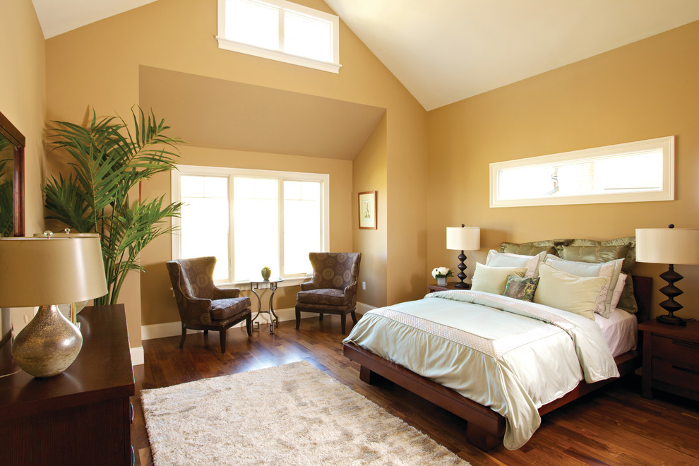 Cette photo montre une chambre chic avec un mur beige et parquet foncé.