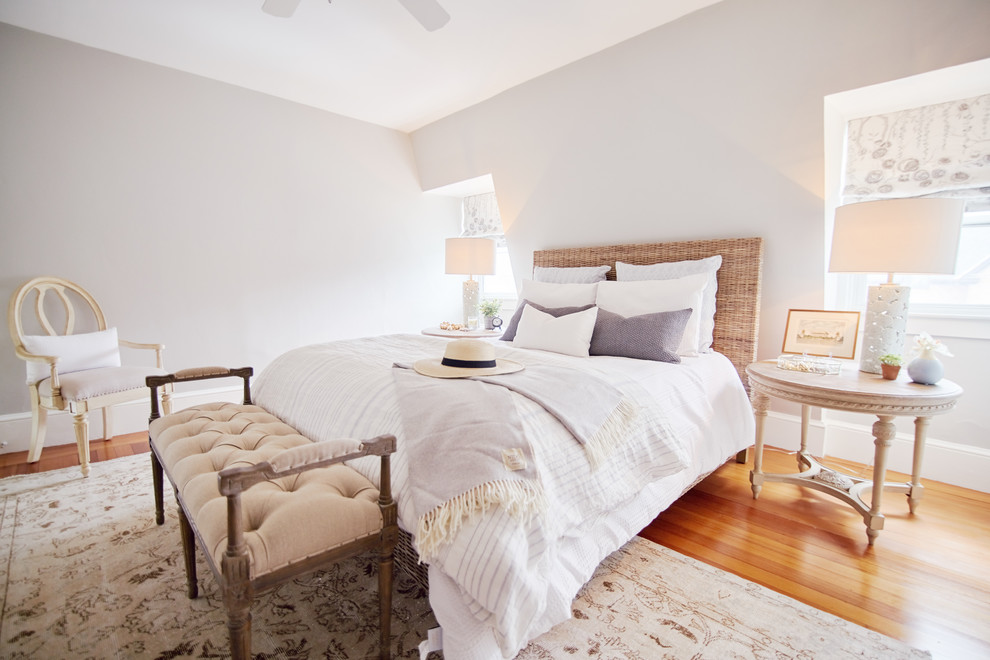 Idée de décoration pour une grande chambre parentale style shabby chic avec un mur blanc, un sol en bois brun et un sol beige.
