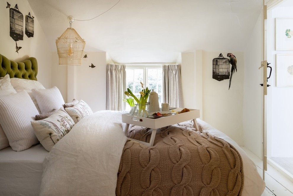 Mid-sized mountain style guest light wood floor and white floor bedroom photo in Devon with white walls