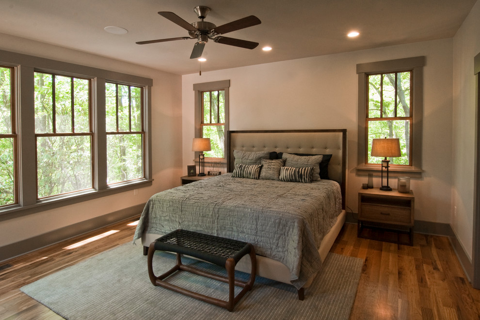 Aménagement d'une chambre d'amis contemporaine avec un mur beige et un sol en bois brun.