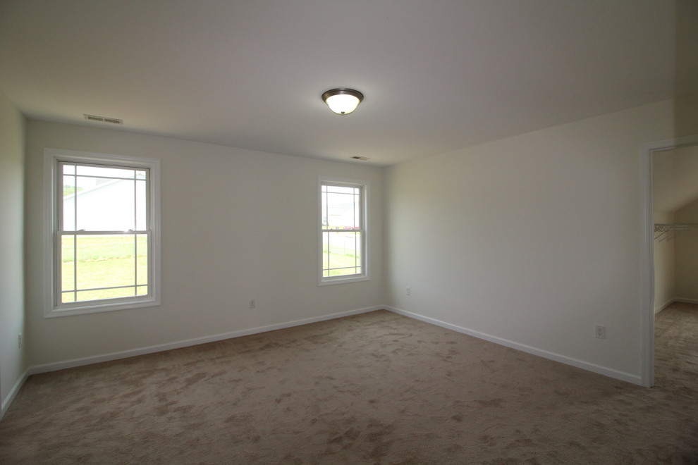 Large traditional master bedroom in Other with white walls and carpet.