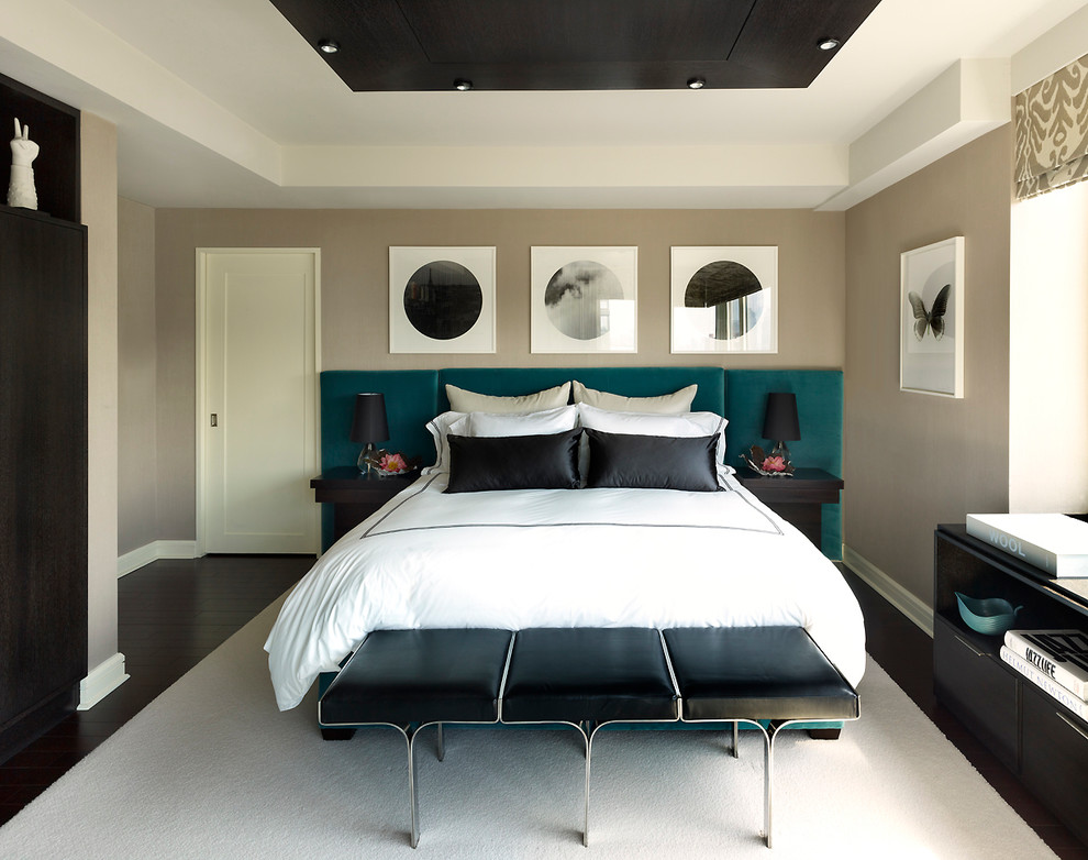 This is an example of a medium sized contemporary master bedroom in New York with dark hardwood flooring, beige walls, no fireplace and brown floors.
