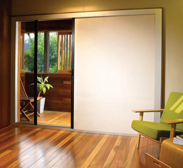 Ejemplo de habitación de invitados minimalista de tamaño medio sin chimenea con paredes beige, suelo de madera en tonos medios y suelo marrón
