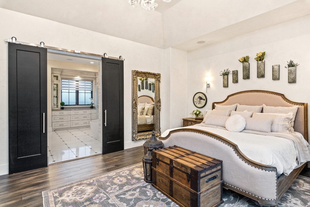 Стильный дизайн: большая хозяйская спальня в стиле кантри с белыми стенами, темным паркетным полом и коричневым полом без камина - последний тренд