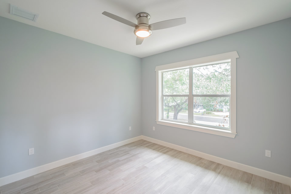 Modelo de habitación de invitados contemporánea de tamaño medio sin chimenea con paredes azules, suelo de madera clara y suelo beige