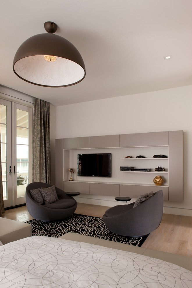 Immagine di una camera da letto minimal con pareti bianche, parquet chiaro e TV