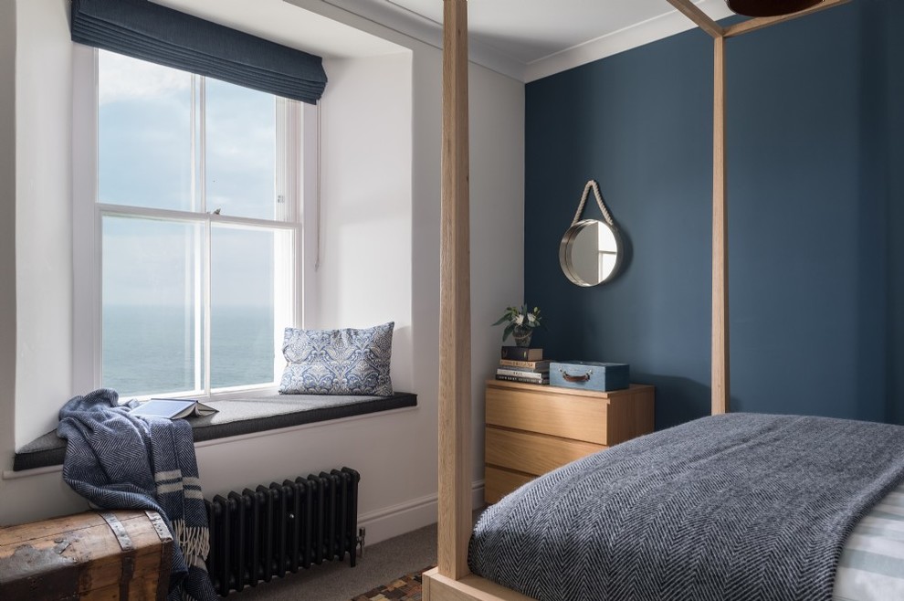 Bild på ett maritimt sovrum, med blå väggar, heltäckningsmatta och grått golv