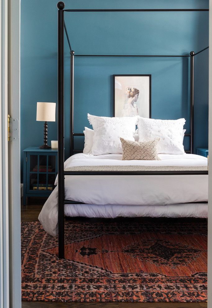 Aménagement d'une chambre classique avec un mur bleu, parquet foncé et un sol marron.