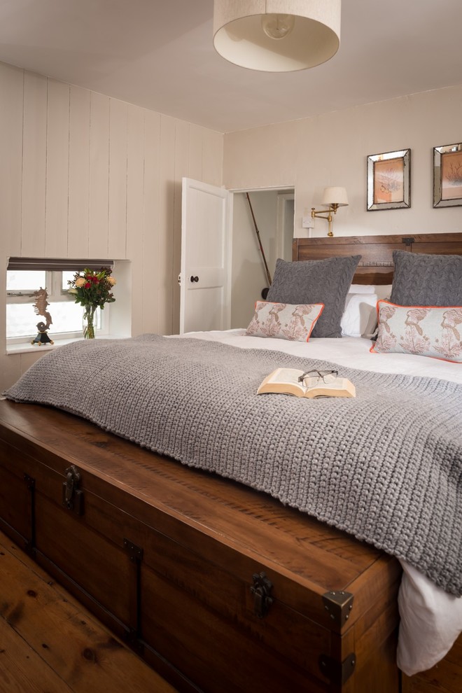 Foto de dormitorio principal costero pequeño con paredes blancas, suelo de madera en tonos medios y suelo marrón