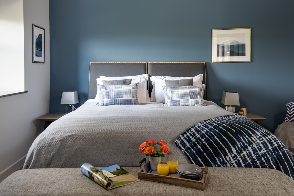 Cette image montre une chambre parentale design de taille moyenne avec un mur bleu, sol en stratifié et un sol gris.