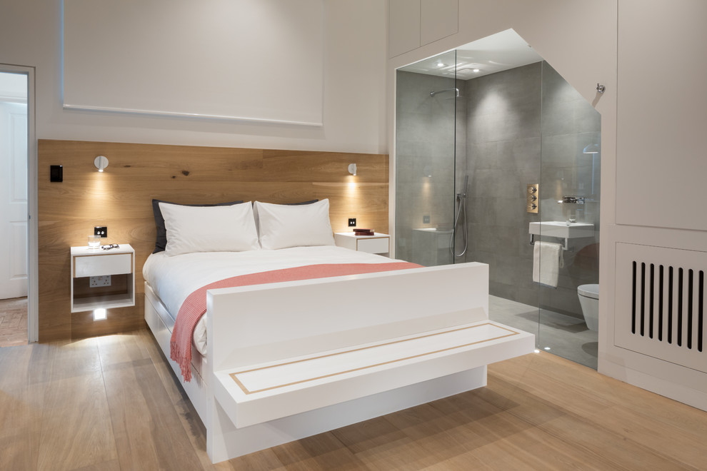 Imagen de dormitorio contemporáneo de tamaño medio con paredes blancas, suelo de madera clara y suelo beige