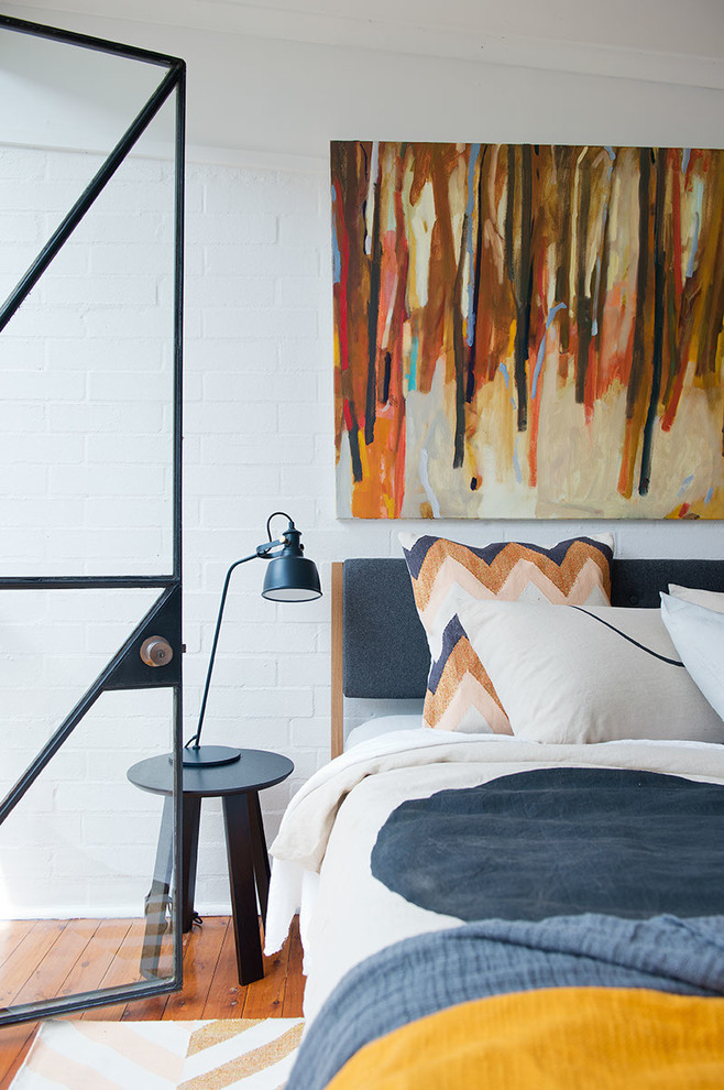 Bild på ett mellanstort minimalistiskt sovrum, med vita väggar och mellanmörkt trägolv