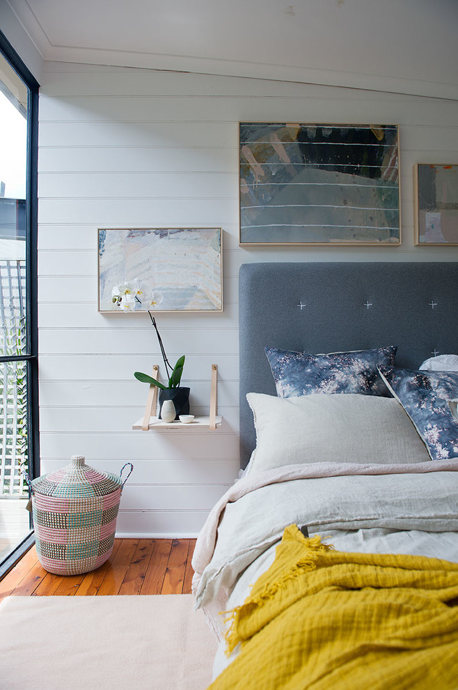 Idéer för ett mellanstort minimalistiskt sovrum, med vita väggar och mellanmörkt trägolv