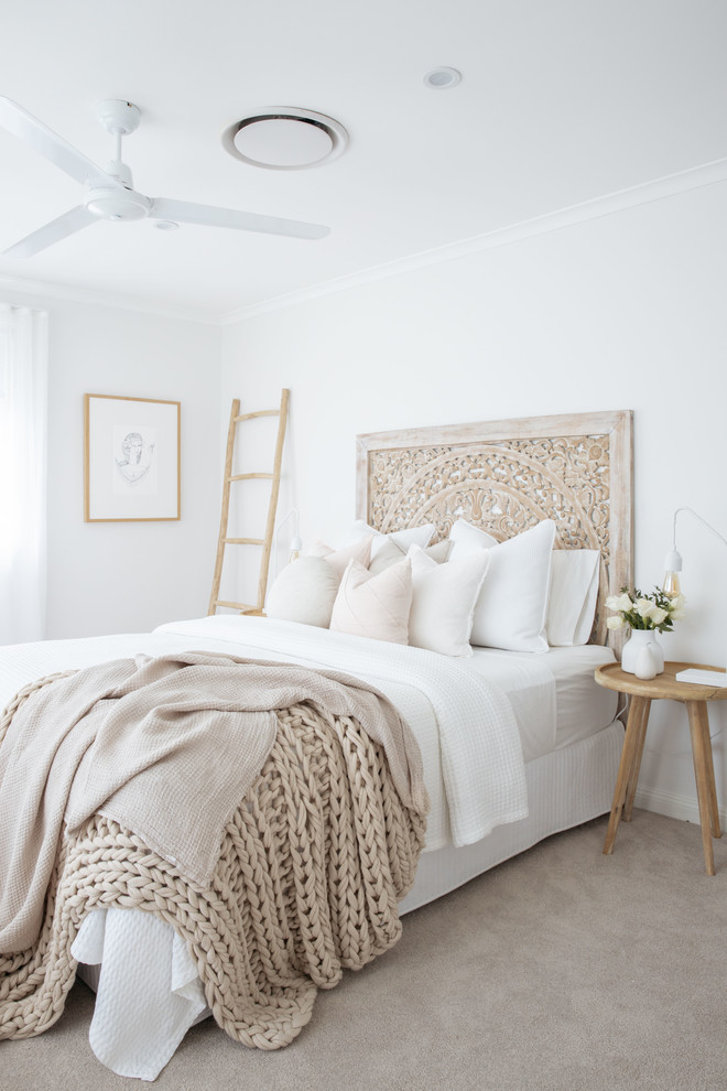 This is an example of a large nautical master bedroom in Sydney with white walls, carpet and grey floors.