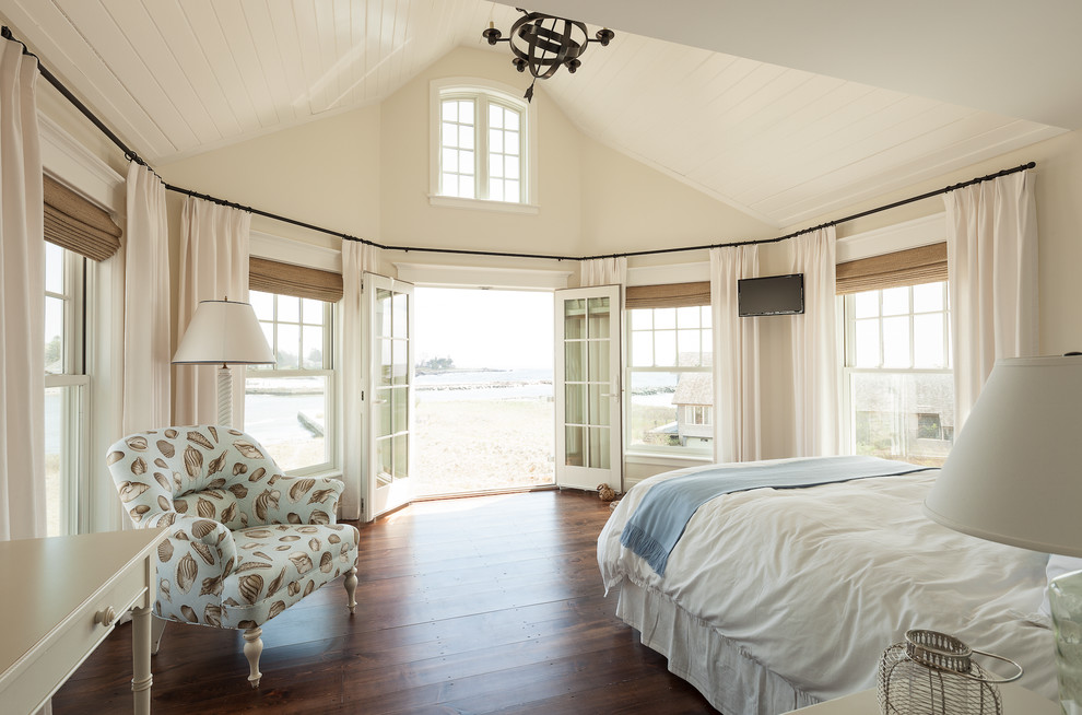 Immagine di un'ampia camera da letto stile marinaro con pareti beige e pavimento in legno massello medio