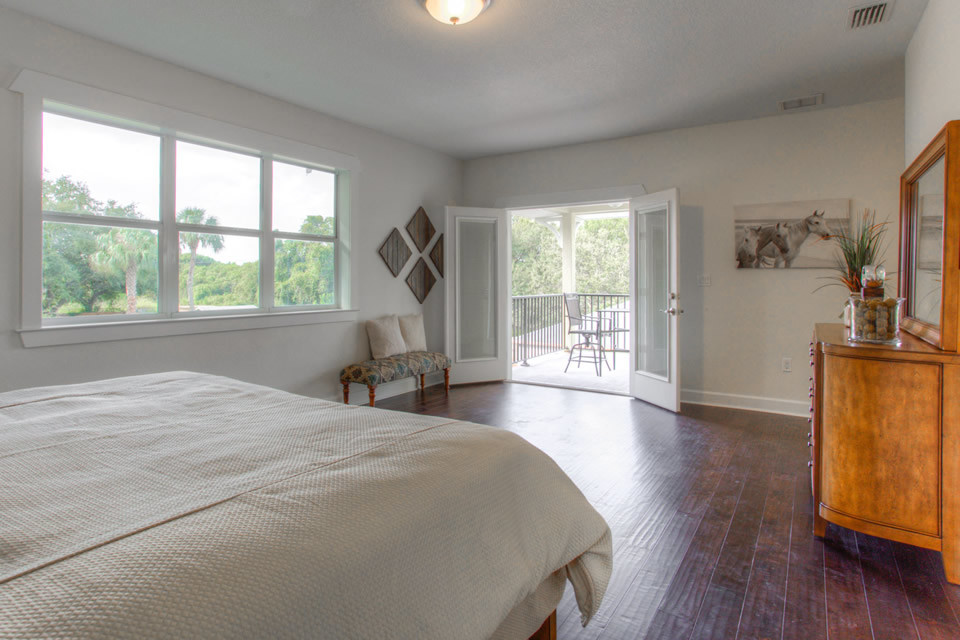 Large transitional master brown floor and medium tone wood floor bedroom photo in Tampa with no fireplace and beige walls