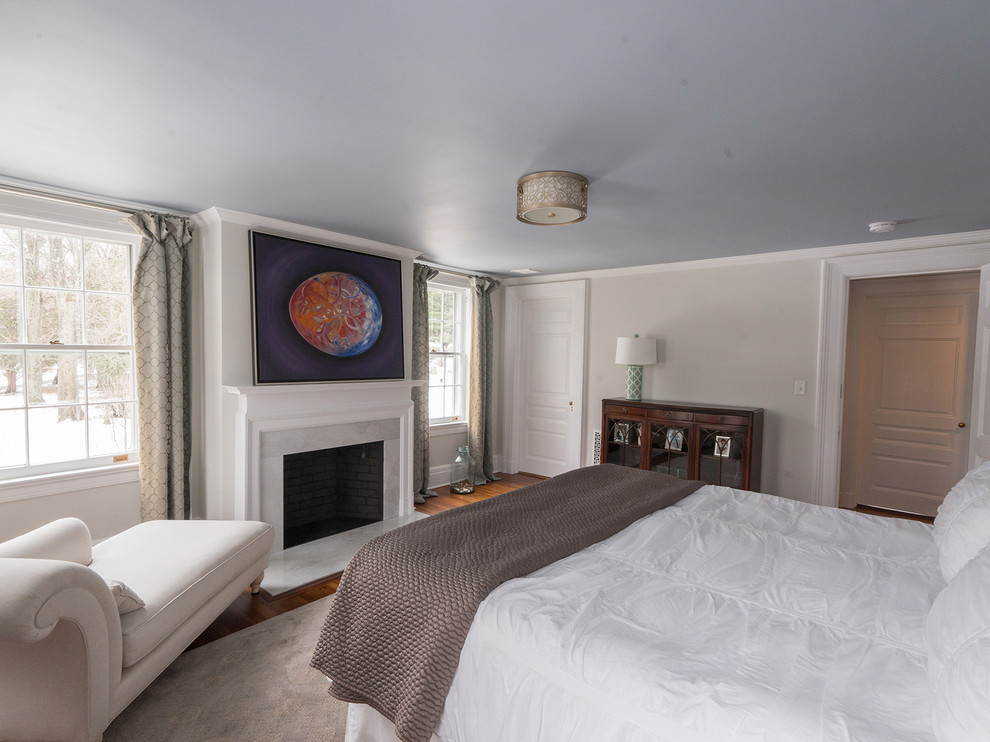 Ejemplo de dormitorio clásico con suelo de madera en tonos medios, paredes rosas y todas las chimeneas