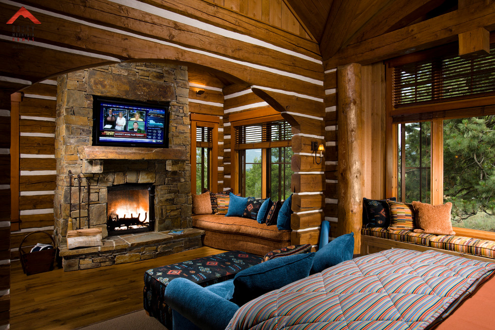 Example of a mountain style bedroom design in Other with a standard fireplace and a stone fireplace