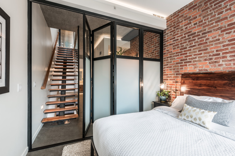 Ejemplo de dormitorio principal urbano pequeño con paredes blancas, suelo de cemento y suelo gris