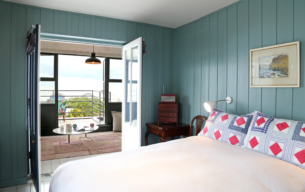 Esempio di una camera da letto stile marino con pareti blu e pavimento in legno verniciato