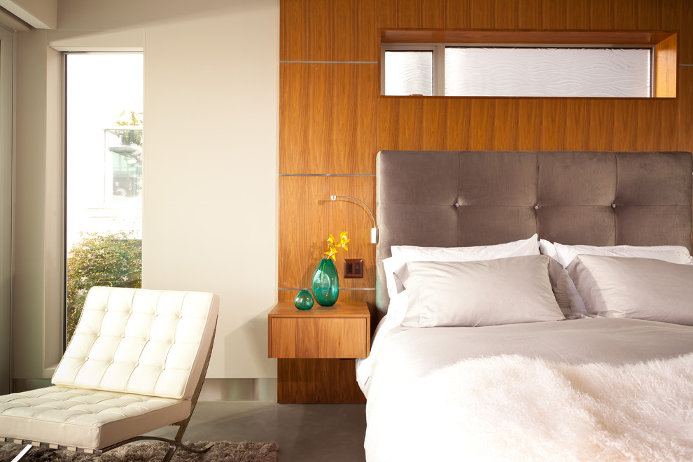 Источник вдохновения для домашнего уюта: спальня в стиле модернизм с белыми стенами, бетонным полом и акцентной стеной