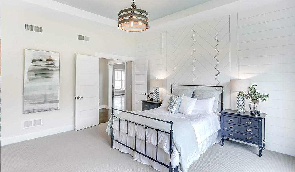 This is an example of an expansive farmhouse master bedroom in Other with grey walls, carpet and beige floors.