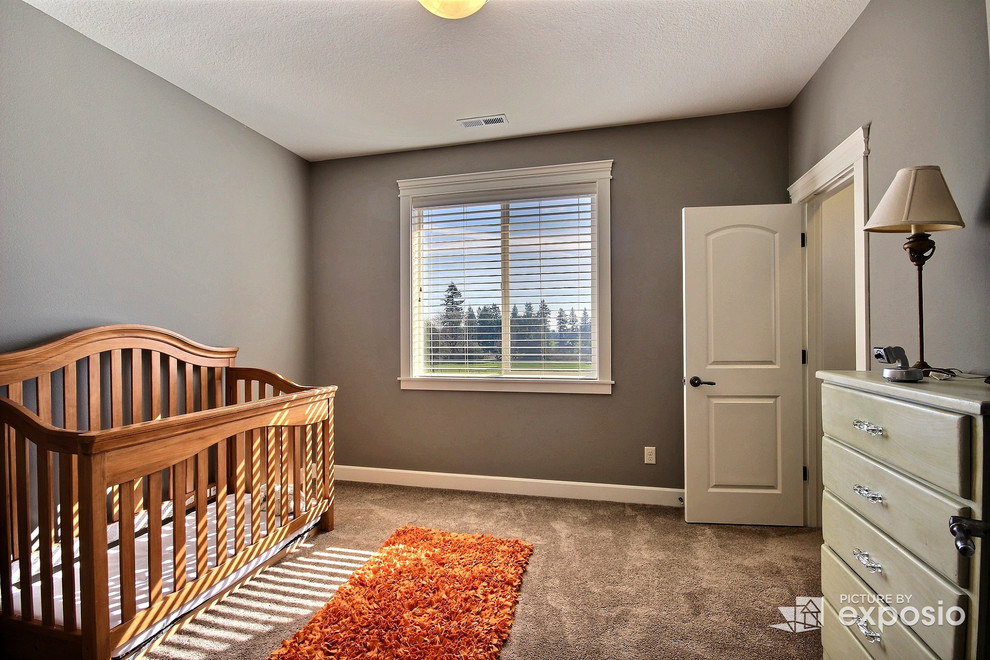 Ejemplo de habitación de bebé clásica renovada grande con paredes grises y moqueta