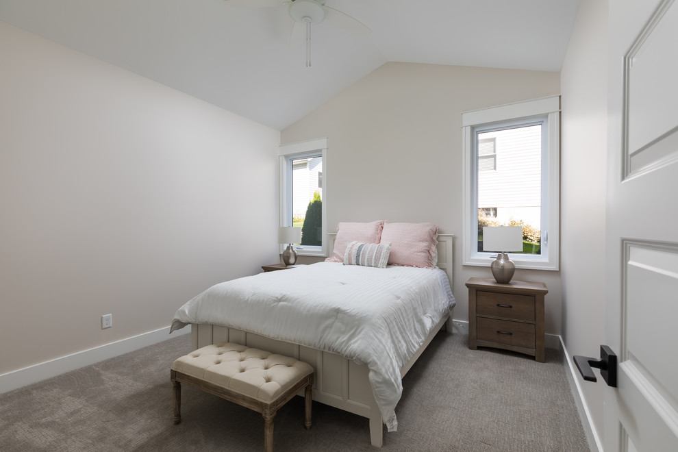 Large beach style guest bedroom in Grand Rapids with white walls, carpet and beige floors.