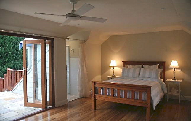Diseño de habitación de invitados de estilo de casa de campo de tamaño medio con paredes verdes y suelo de bambú