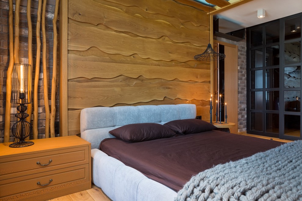 Пример оригинального дизайна: хозяйская спальня среднего размера в стиле рустика с разноцветными стенами, светлым паркетным полом, стандартным камином и фасадом камина из кирпича