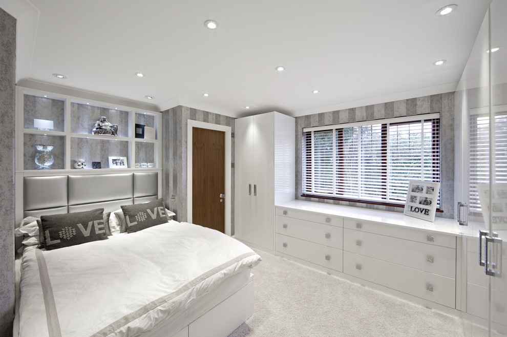 Imagen de dormitorio tipo loft contemporáneo de tamaño medio sin chimenea con paredes grises y moqueta