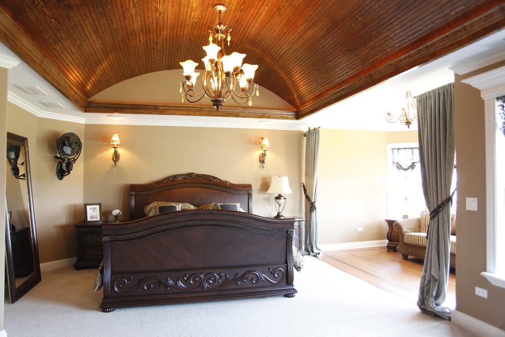 На фото: большая хозяйская спальня в классическом стиле с бежевыми стенами и ковровым покрытием с