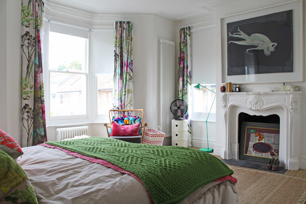 На фото: спальня в современном стиле с белыми стенами, ковровым покрытием и стандартным камином