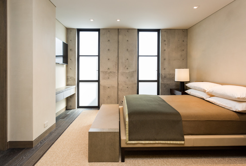 Inspiration pour une chambre design avec un mur beige, parquet foncé et un sol marron.