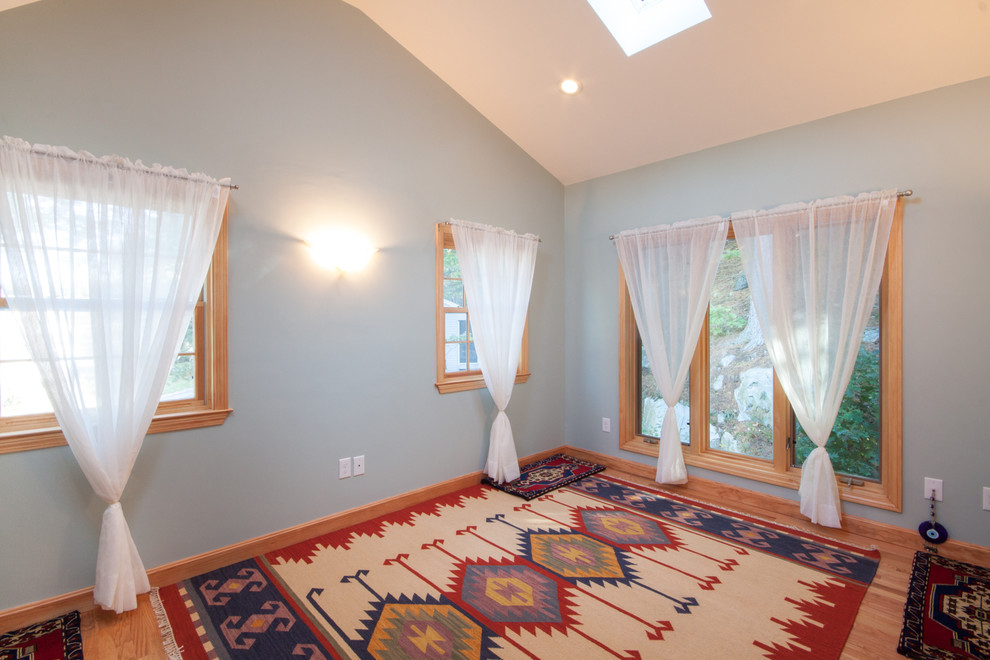 Aménagement d'une chambre d'amis classique de taille moyenne avec un mur bleu, un sol en bois brun et aucune cheminée.