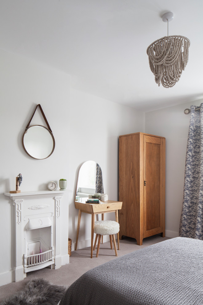 サセックスにある中くらいな北欧スタイルのおしゃれな客用寝室 (白い壁、カーペット敷き、金属の暖炉まわり、グレーの床) のインテリア