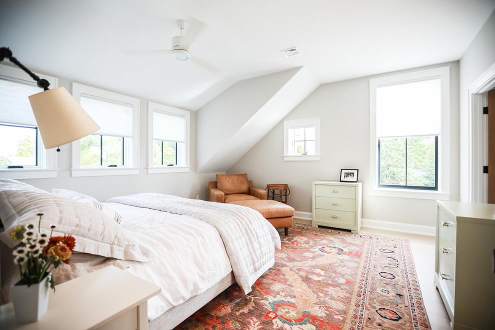 Imagen de dormitorio tradicional renovado con paredes grises, suelo de madera clara y suelo beige
