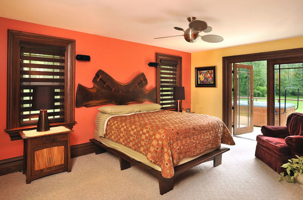他の地域にある広いエクレクティックスタイルのおしゃれな主寝室 (オレンジの壁、カーペット敷き)
