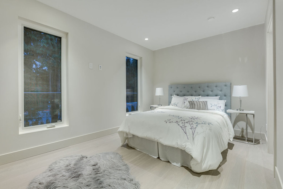 Cette photo montre une chambre d'amis tendance de taille moyenne avec un mur gris, parquet clair et un sol gris.