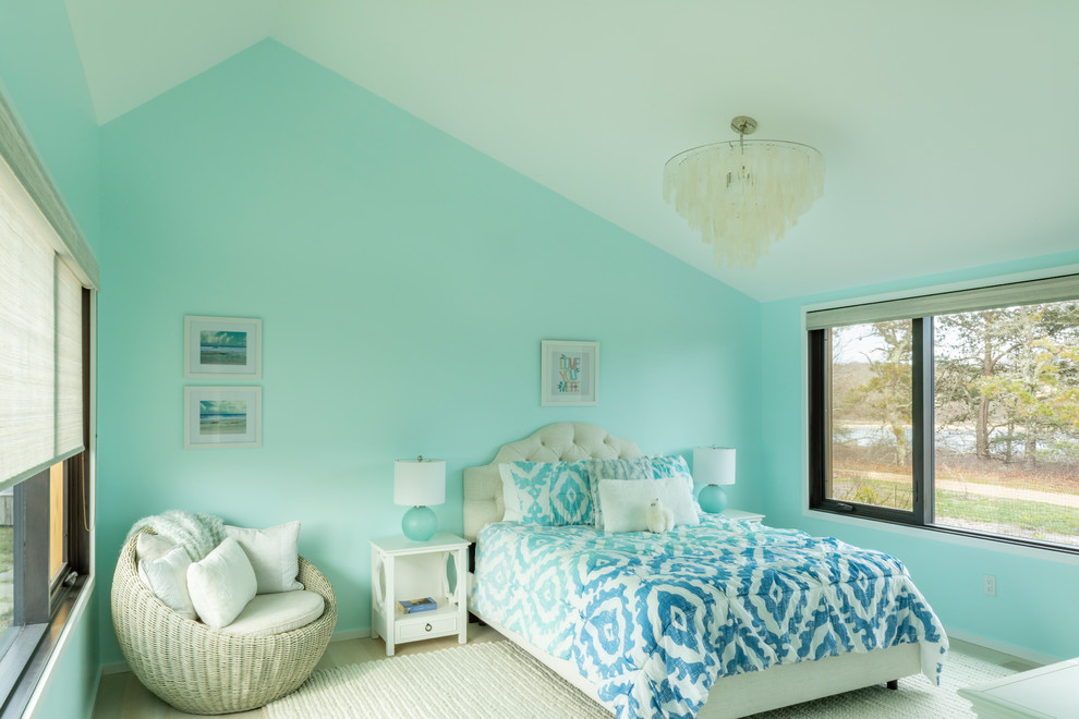 Modelo de habitación de invitados marinera de tamaño medio con paredes azules, suelo de madera clara y suelo beige