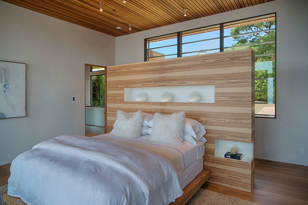 Foto de habitación de invitados minimalista de tamaño medio sin chimenea con paredes blancas, suelo de madera clara y suelo beige