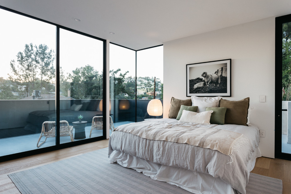 ロサンゼルスにある中くらいなコンテンポラリースタイルのおしゃれな主寝室 (白い壁、無垢フローリング、ベージュの床) のインテリア
