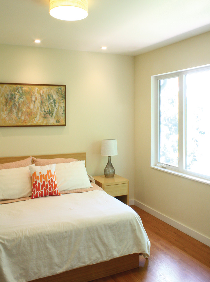 Medium sized modern master bedroom with white walls, medium hardwood flooring and no fireplace.