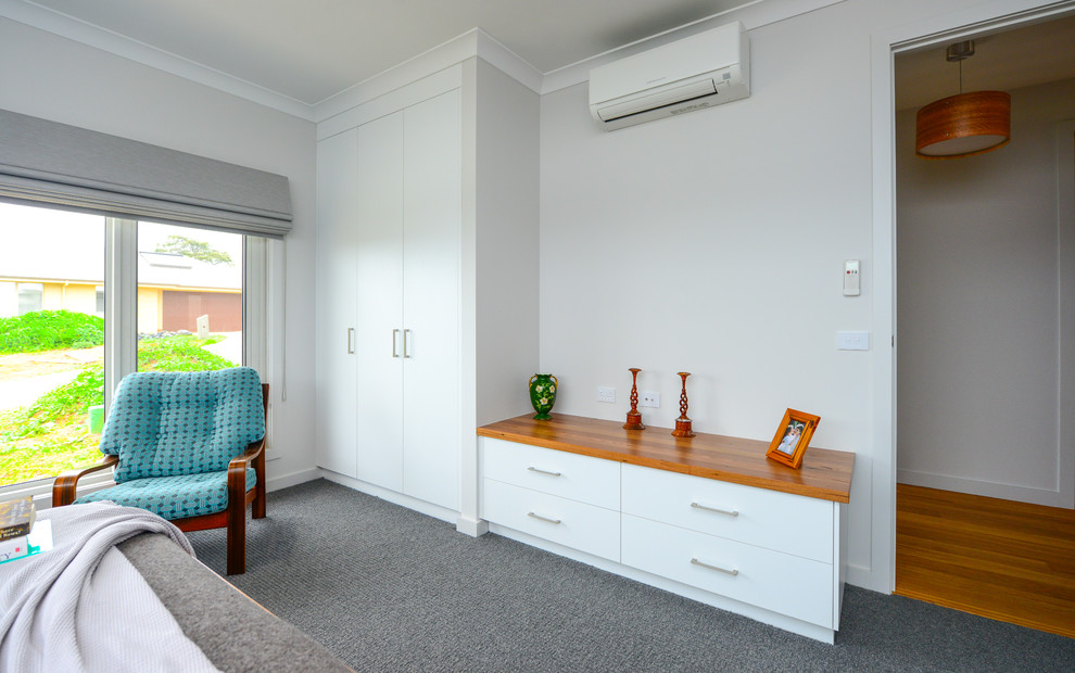 Inspiration för små moderna gästrum, med vita väggar, heltäckningsmatta och grått golv