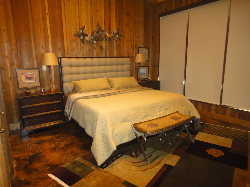 На фото: большая гостевая спальня (комната для гостей) в стиле фьюжн с коричневыми стенами и бетонным полом с