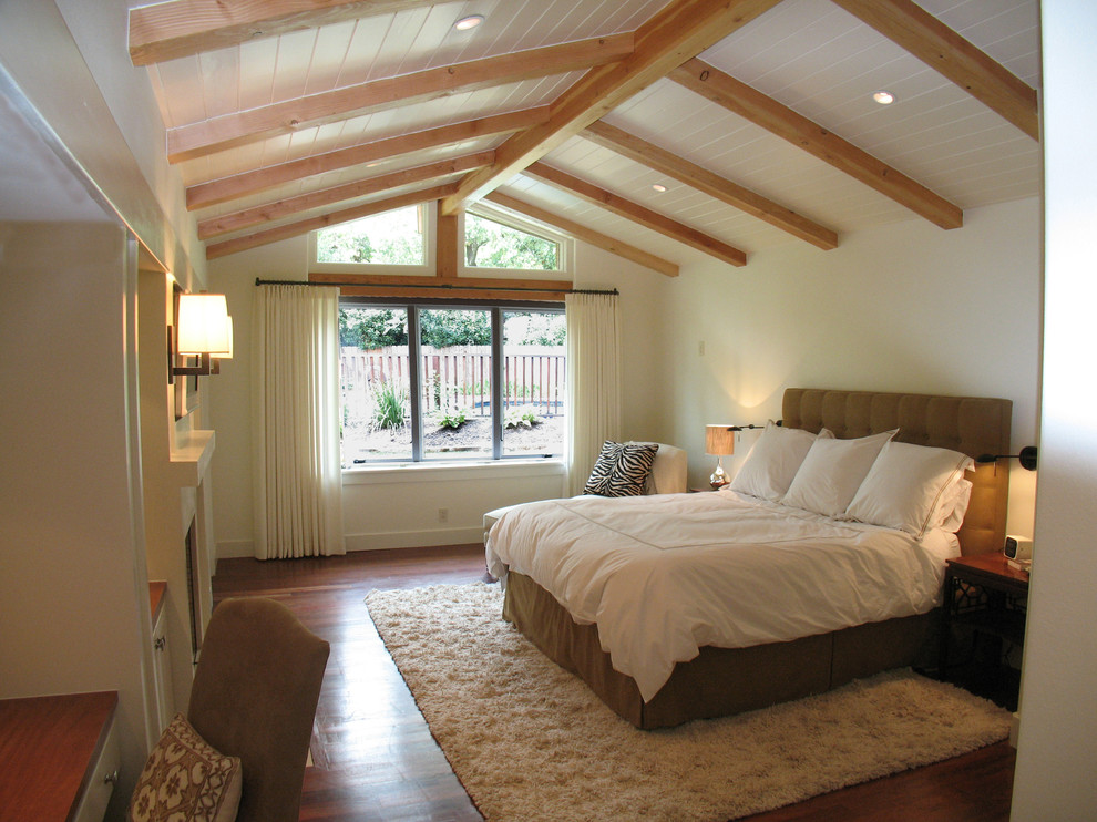 Foto på ett funkis sovrum, med vita väggar och mörkt trägolv