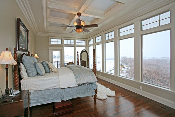 Diseño de dormitorio principal clásico grande sin chimenea con suelo de madera en tonos medios y paredes blancas
