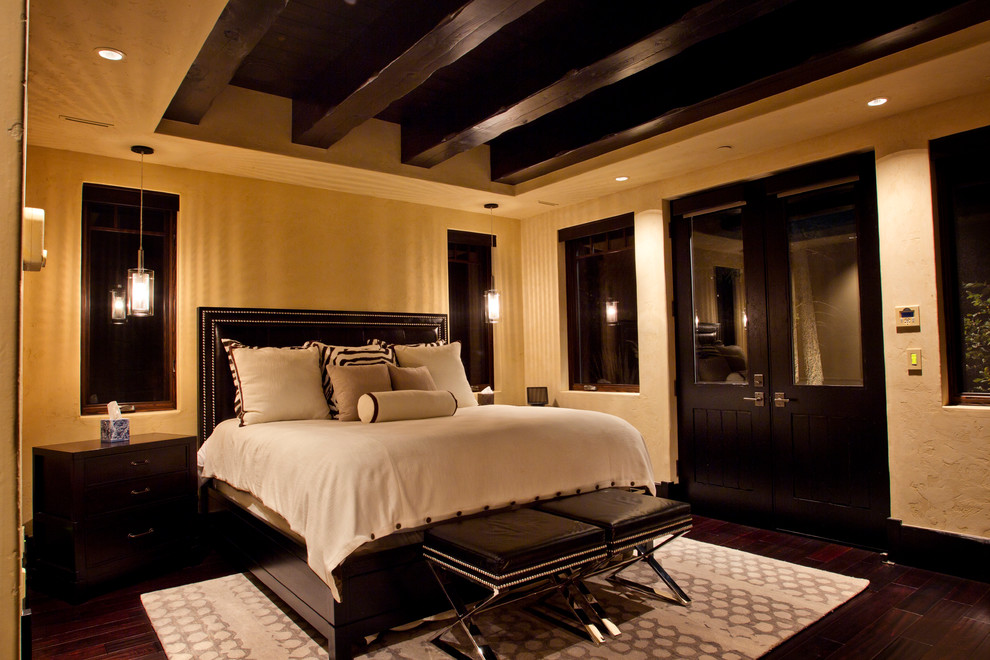 Foto di una camera da letto rustica con pareti beige e parquet scuro