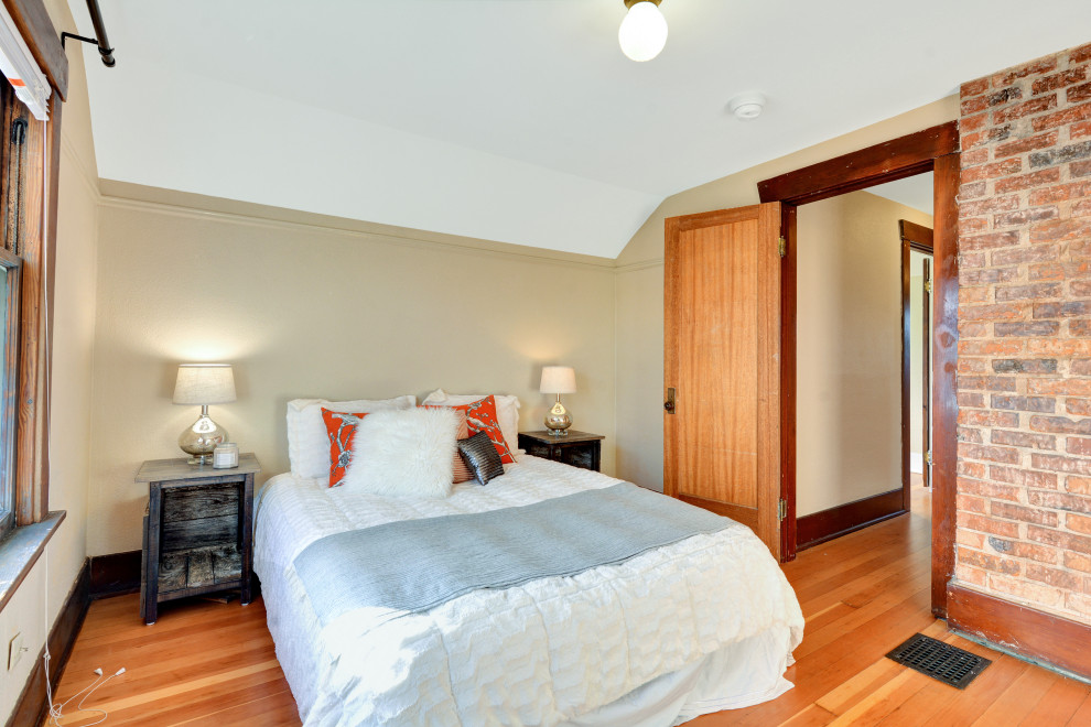 This is an example of a medium sized traditional guest bedroom in Seattle with beige walls, medium hardwood flooring and brown floors.
